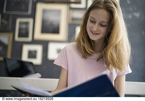 Mädchen liest in einem Übungsbuch zu Hause