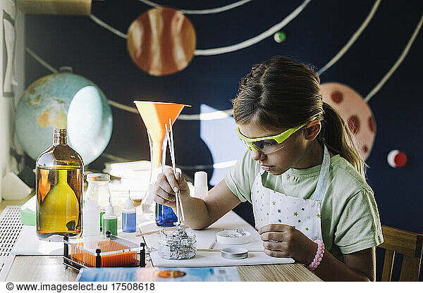 Mädchen macht wissenschaftliches Experiment am Tisch