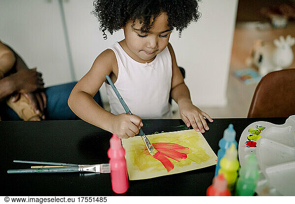 Mädchen malt auf Papier am Tisch