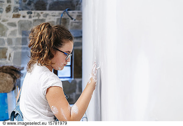 Mädchen malt mit dem Finger an einer Wand