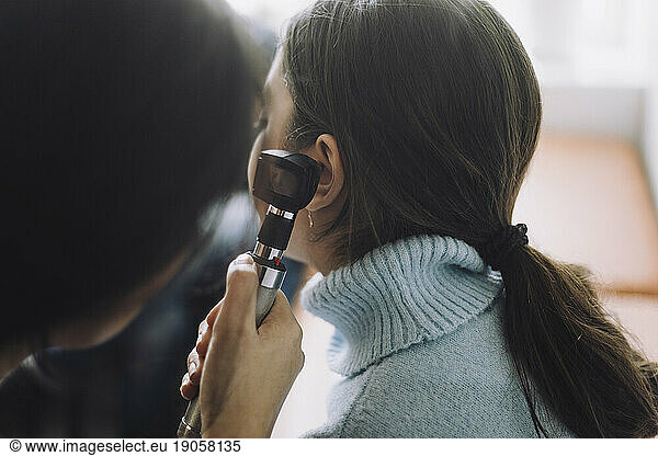 Mädchen mit Rollkragenpullover unterzieht sich im Krankenhaus einem Hörtest