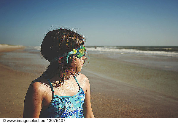 Mädchen mit Schwimmbrille beim Blick aufs Meer am St. Augustine Beach bei Sonnenschein