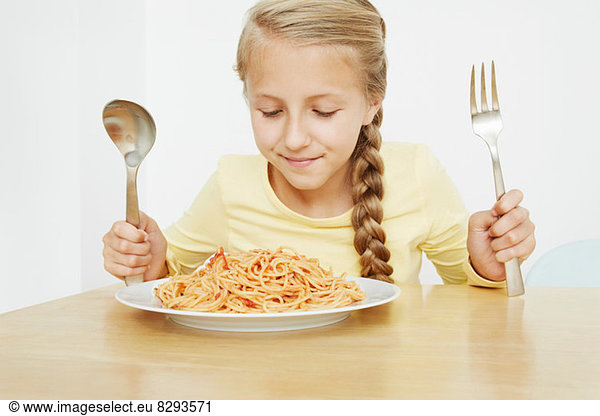 Mädchen mit Spaghettiteller und übergroßem Besteck
