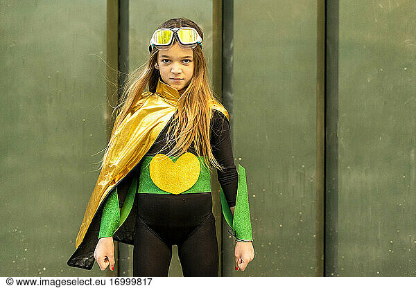 Mädchen posiert im Superheldin-Kostüm