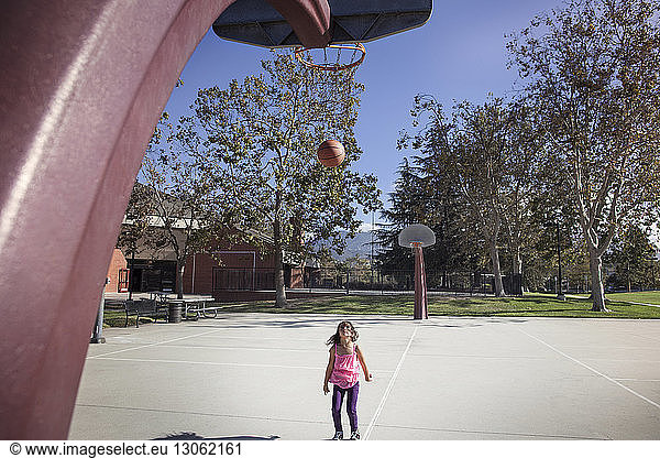 Mädchen sieht Ball vom Basketballkorb fallen