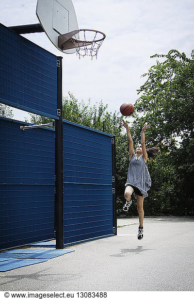 Mädchen spielt Basketball auf dem Platz