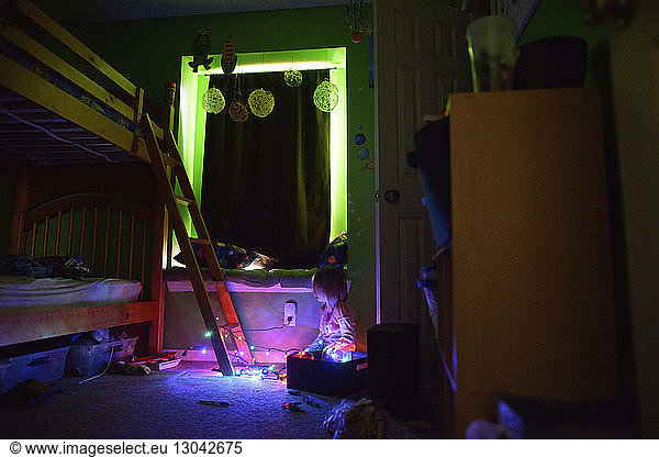 Mädchen spielt zu Hause mit beleuchtetem Saitenlicht