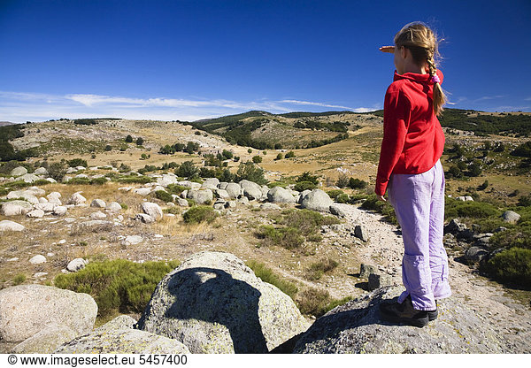 Mädchen steht auf einem Felsen mit Blick über die Naturlandschaft im Cevennen Nationalpark  Frankreich  Europa