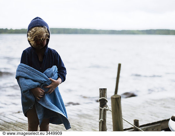 Mädchen umwickelt Handtuch  Stand auf jetty