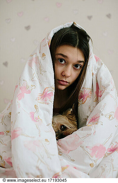 Mädchen und ihr Haustier mit Decke zugedeckt