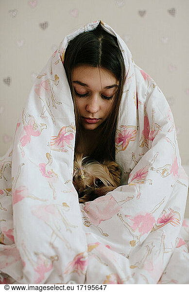 Mädchen und ihr Haustier mit Decke zugedeckt