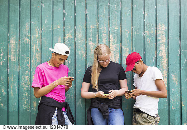 Mädchen und Jungen im Teenageralter (14-15)  die Smartphones benutzen