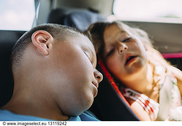Müde Geschwister schlafen im Auto