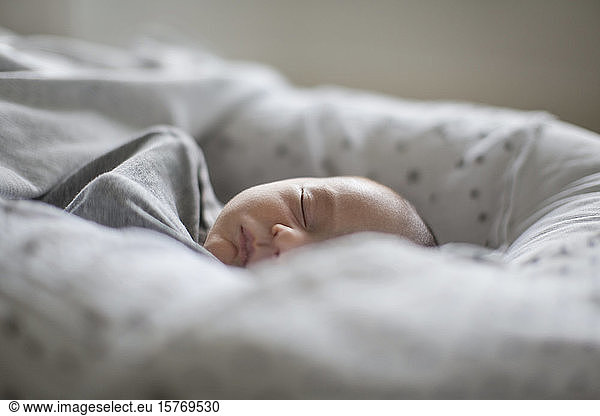 Müde unschuldige neugeborenes Baby Junge schlafen in Moses sleeper Korb