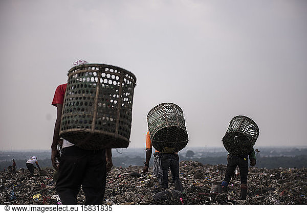 Müllsammler gehen auf der Deponie auf der Suche nach Materialien zum Recycling
