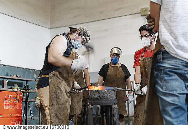 Männer beim Schmieden von Metall in einer Werkstatt