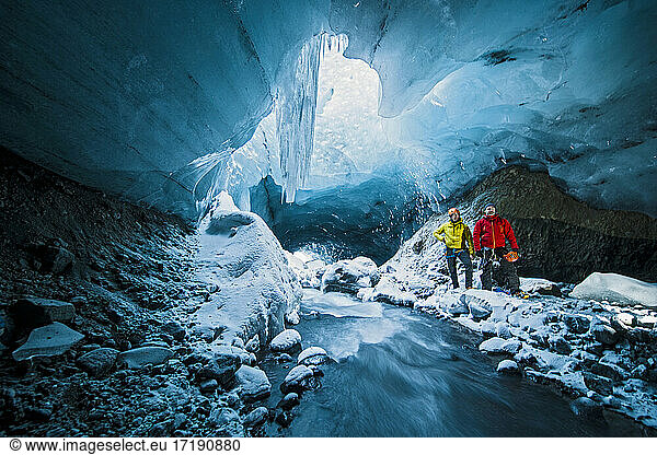 Männer erforschen Eishöhle in Thórsmörk - Island
