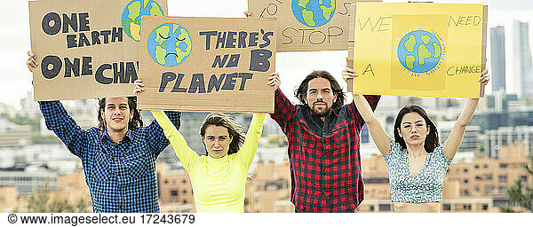 Männer und Frauen protestieren mit einem Transparent gegen den Klimawandel