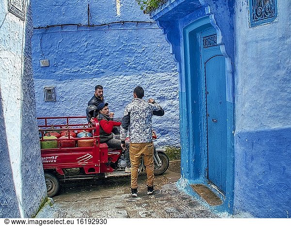 Männer unterhalten sich in einer engen Gasse in der Blauen Medina  Chefchaouen  Marokko.