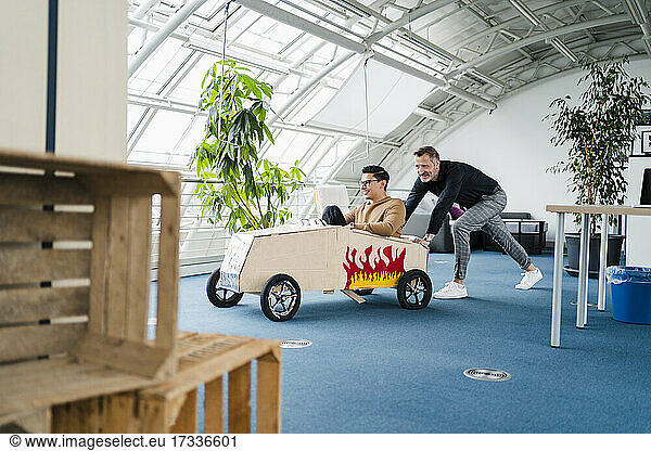 Männliche Kollegen mit Spielzeugauto im Kreativbüro