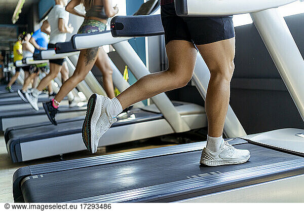 Männliche und weibliche Athleten beim Laufen auf dem Laufband im Fitnessstudio