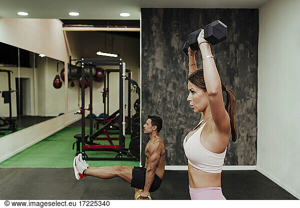 Männliche und weibliche Athleten trainieren mit Geräten im Fitnessstudio