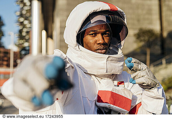 Männlicher Astronaut mit Weltraumhelm gestikuliert