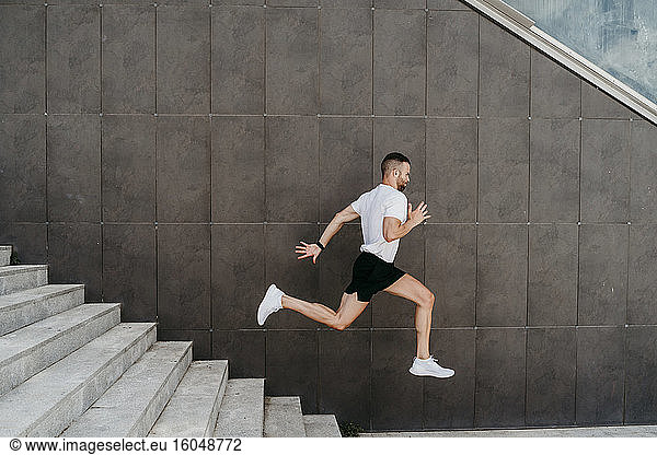 Männlicher Athlet  der eine Treppe hinunterläuft
