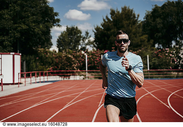 Männlicher Athlet läuft auf Tartanbahn