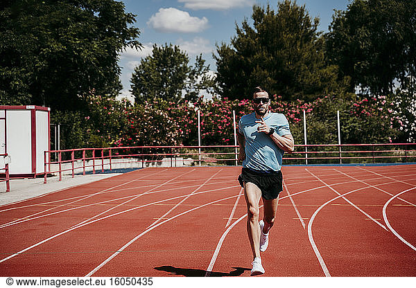 Männlicher Athlet läuft auf Tartanbahn