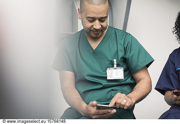 Männlicher Chirurg mit Smartphone