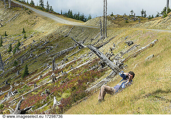 Männlicher Fotograf  der auf einer Bergwiese fotografiert