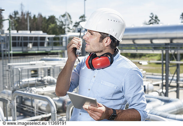 Männlicher Ingenieur im Gespräch mit Walkie-Talkie in einem geothermischen Kraftwerk