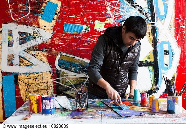 Männlicher Künstler schafft gemaltes Kunstwerk