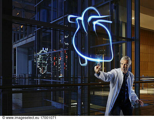 Männlicher Kardiologe  der ein Herz im Labor eines Krankenhauses beleuchtet