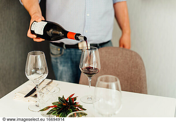 Männlicher Kellner serviert Rotwein in einem Restaurant