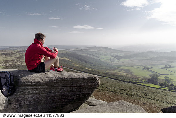 Männlicher Läufer mit Blick von der Spitze von Stanage Edge  Peak District  Derbyshire  UK