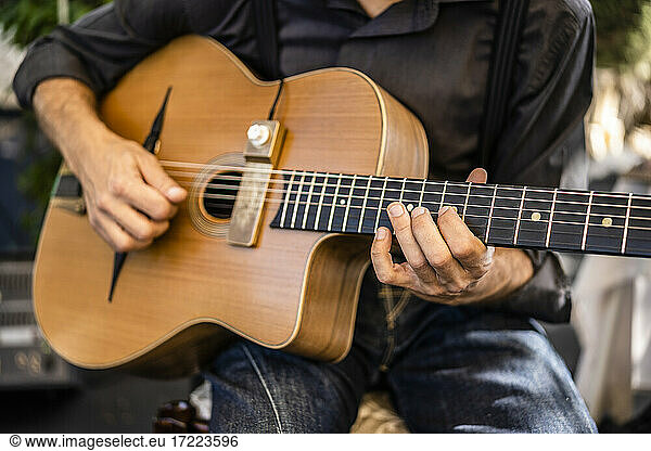 Männlicher Musiker spielt Gitarre während einer Veranstaltung