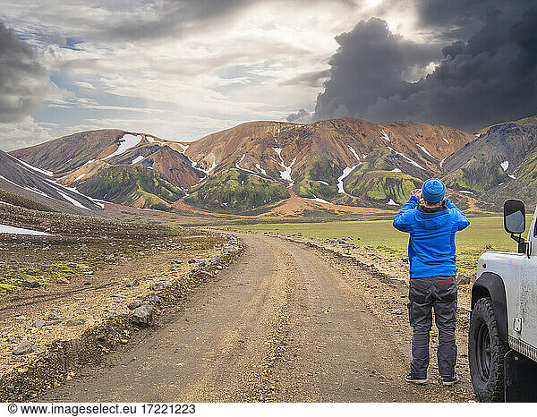 Männlicher Reisender  der die vulkanische Landschaft von Landmannalaugar fotografiert