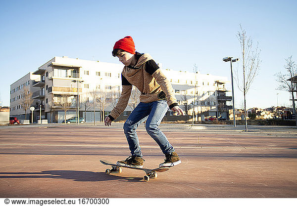 Männlicher Skateboarder fährt und übt Skateboard in der Stadt im Freien