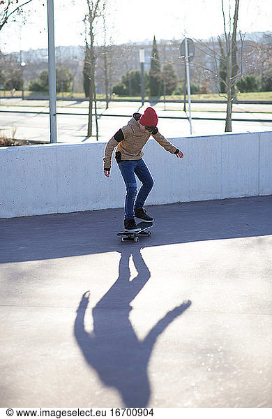 Männlicher Skateboarder fährt und übt Skateboard in der Stadt im Freien