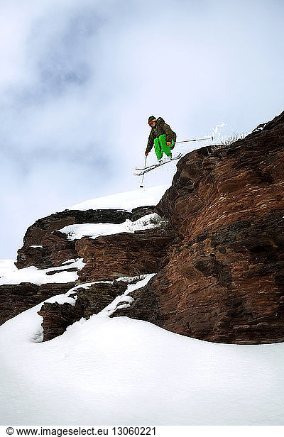 Männlicher Skifahrer beim Abfahrtslauf am Berg
