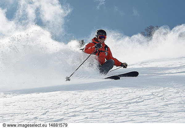 Männlicher Skifahrer beim Skifahren am Berghang  Blick aus niedrigem Winkel  Alpe-d'Huez  Rhône-Alpes  Frankreich
