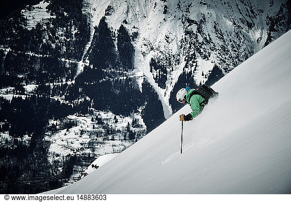 Männlicher Skifahrer  der einen steilen Berghang hinunterfährt  Alpe-d'Huez  Rhône-Alpes  Frankreich