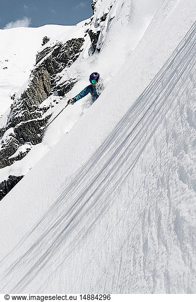 Männlicher Skifahrer rast den steilen Berghang hinunter  Alpe-d'Huez  Rhône-Alpes  Frankreich