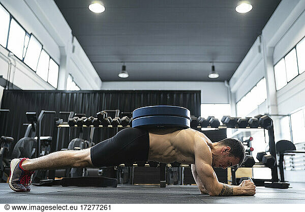 Männlicher Sportler in der Plank-Position im Fitnessstudio
