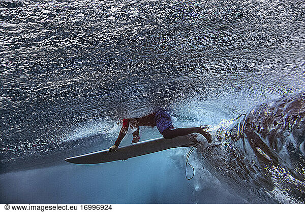 Männlicher Surfer mit Surfbrett im Meer