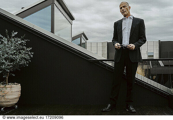 Männlicher Unternehmer steht auf dem Balkon eines Büros