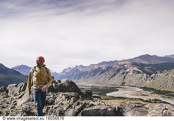 Männlicher Wanderer  der in Patagonien  Argentinien  auf Felsen gegen Berge läuft