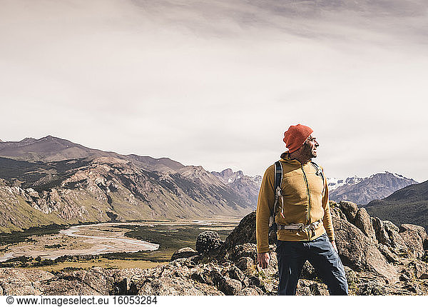 Männlicher Wanderer  der wegschaut  während er gegen Berge in Patagonien  Argentinien  steht